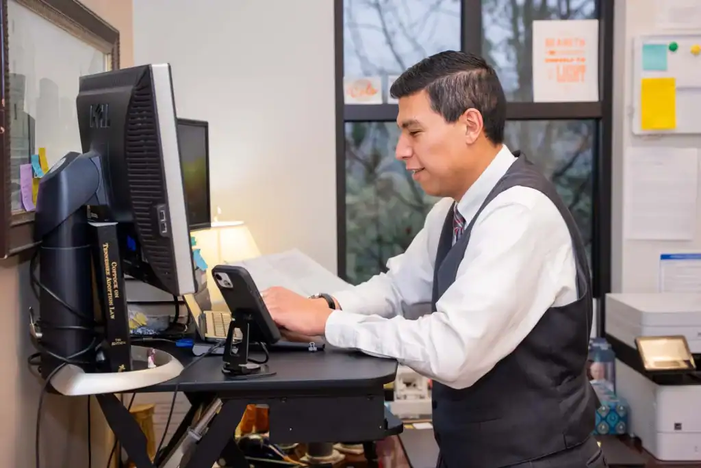 Attorney working at his office desk with computer and phone.