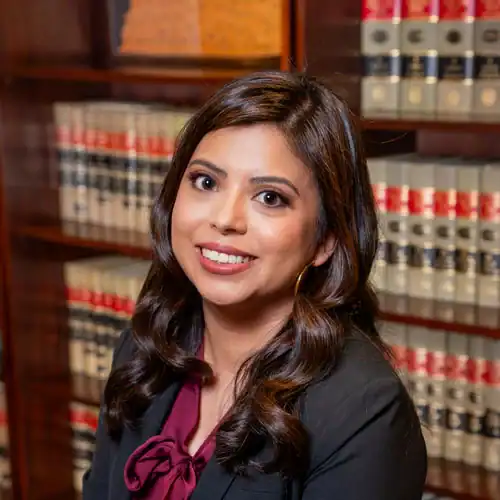 Professional woman lawyer smiling in law library with legal books at Bonano & Associates.